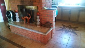 Una chimenea de ladrillo con un marco de piedra, un pez decorativo y un candelabro.