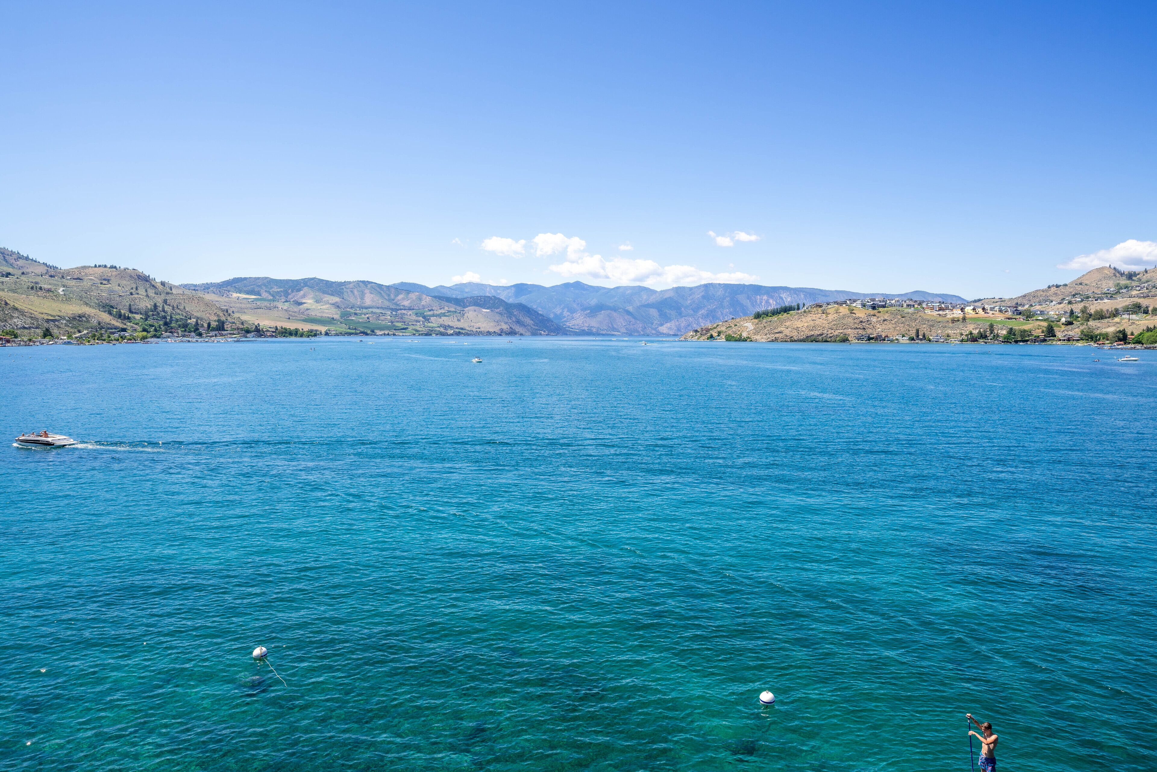 A large body of water with boats and a person taking a photo.