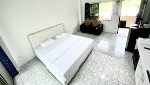 Une chambre d’h ôtel avec un lit, un canapé, un bureau et une fenêtre donnant sur un paysage agréable.