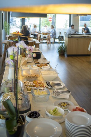 A buffet setup with various food items and utensils.