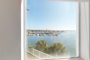A balcony with a view of a marina and a distant cityscape.