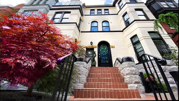 A grand building with a prominent entrance, stone steps, and a large door.