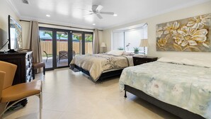 A bedroom with a bed, a desk, a chair, a ceiling fan, a window with blinds, and a door leading to an outdoor area. - PRIVATE ISLAND HOME WITH POOL & WALK TO PRIVATE BEACH - GUEST FAVORITE! Must see (Pompano Beach)