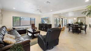 A spacious living room with a sectional sofa, a recliner, a dining area with a table and chairs, and a ceiling fan. - PRIVATE ISLAND HOME WITH POOL & WALK TO PRIVATE BEACH - GUEST FAVORITE! Must see (Pompano Beach)