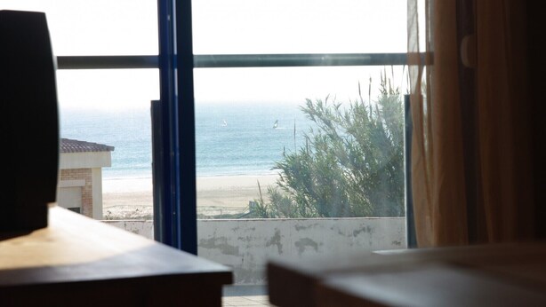 A room with a view of the beach and ocean through large windows. - 112 - Apartamento Blue I (Tarifa)