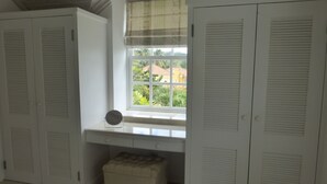 Una habitación con ventana, un escritorio y dos armarios.