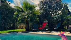 Una piscina con agua cristalina, rodeada de exuberante follaje y palmeras.