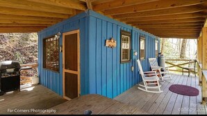 A blue cabin with a wooden deck, a grill, and a rocking chair. - Cozy Cabin at a GREAT price (Whittier)