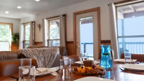 A dining area with a table set for two, featuring a pitcher, plates, glasses, and a bowl of snacks. - Trails End Cabin with a hot tub, fire pit, & indoor pool! (Bryant)