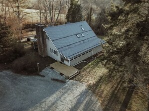A single-story house with a sloped roof, a chimney, and a small porch. - Experience Pisgah Forest charm near Dupont State and Pisgah National Forests (Pisgah Forest)