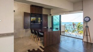 Una cucina moderna con mobili in legno scuro, un'isola centrale e un'area pranzo con sedie.