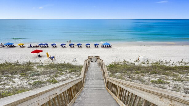 A wooden boardwalk leading to a beach with rows of beach chairs and umbrellas. - Stunning & Spacious 4BR Beachfront Condo at Adagio B202 with Gulf Front Views! (Santa Rosa Beach)