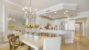 A spacious kitchen with white cabinetry, a central island, and a chandelier. - Stunning & Spacious 4BR Beachfront Condo at Adagio B202 with Gulf Front Views! (Santa Rosa Beach)