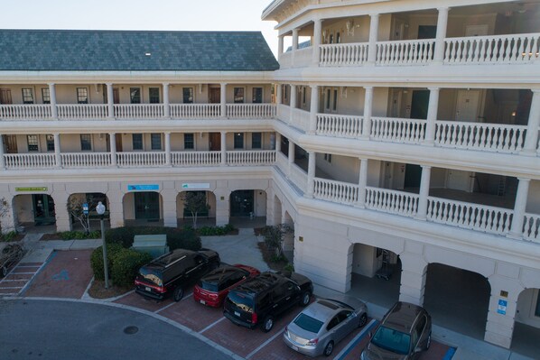Un hôtel à plusieurs étages doté d’une cour intérieure, d’un parking et de nombreux balcons.
