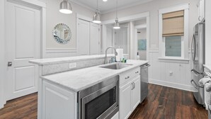 A kitchen with white cabinetry, a marble countertop, stainless steel appliances, and pendant lighting. - 5 BDRM & 6 seat golf cart! On the green, everything for KIDS, 2 King BDRMs (Santa Rosa Beach)