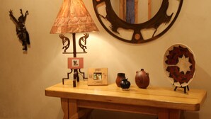 Ein Holzkonsolentisch mit Lampe, Spiegel und Dekorationselementen.