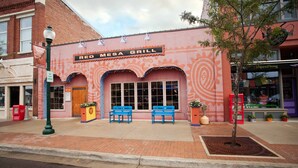 A Red Mesa Grill with a brick facade, two blue benches outside, and a street lamp.