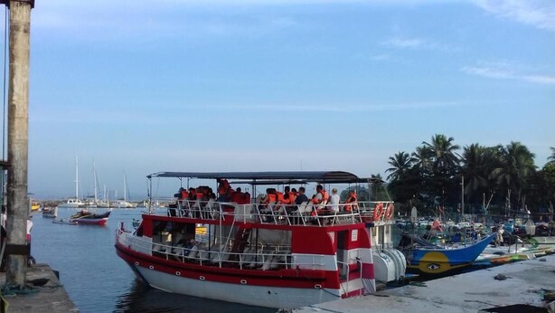 A ferry docked at a pier with several boats in the background. - Prasad Suomi Villa (Matara)