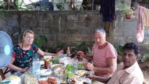 A dining table with various dishes, a fan, and potted plants in the background. - Prasad Suomi Villa (Matara)
