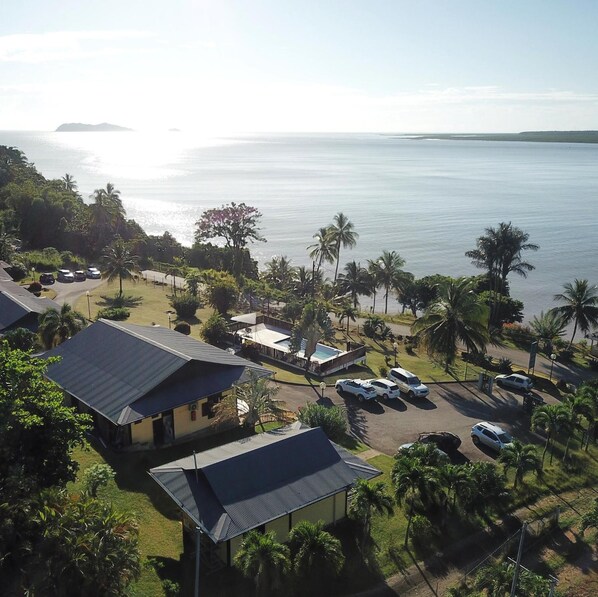 A coastal resort with multiple buildings, a parking area, and a view of the sea.