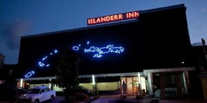 The exterior of the Islanderr Inn with a neon sign displaying a map of the islands. - Islanderr Inn (Port Blair)