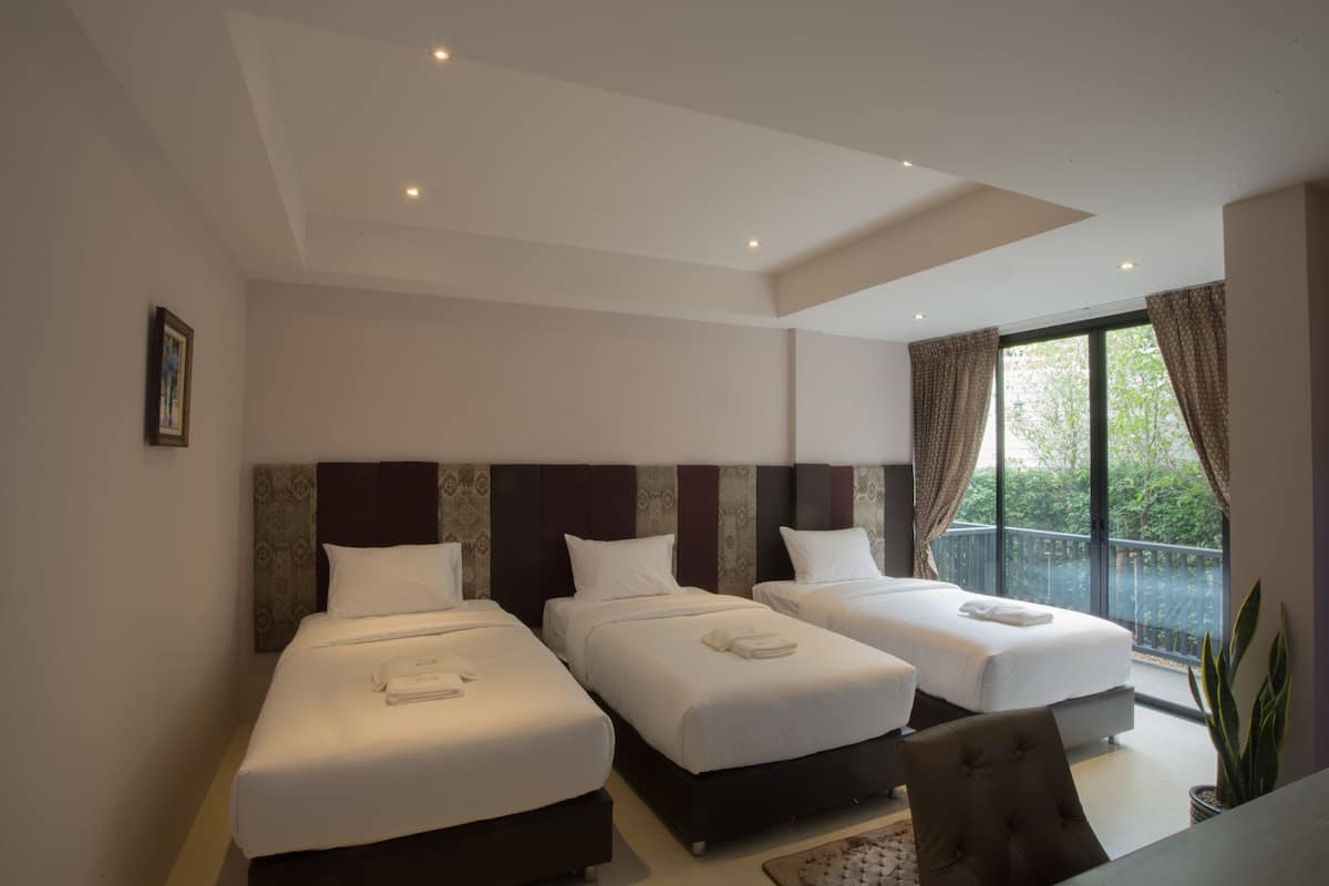 Een hotelkamer met twee bedden, een balkon en een groot raam.