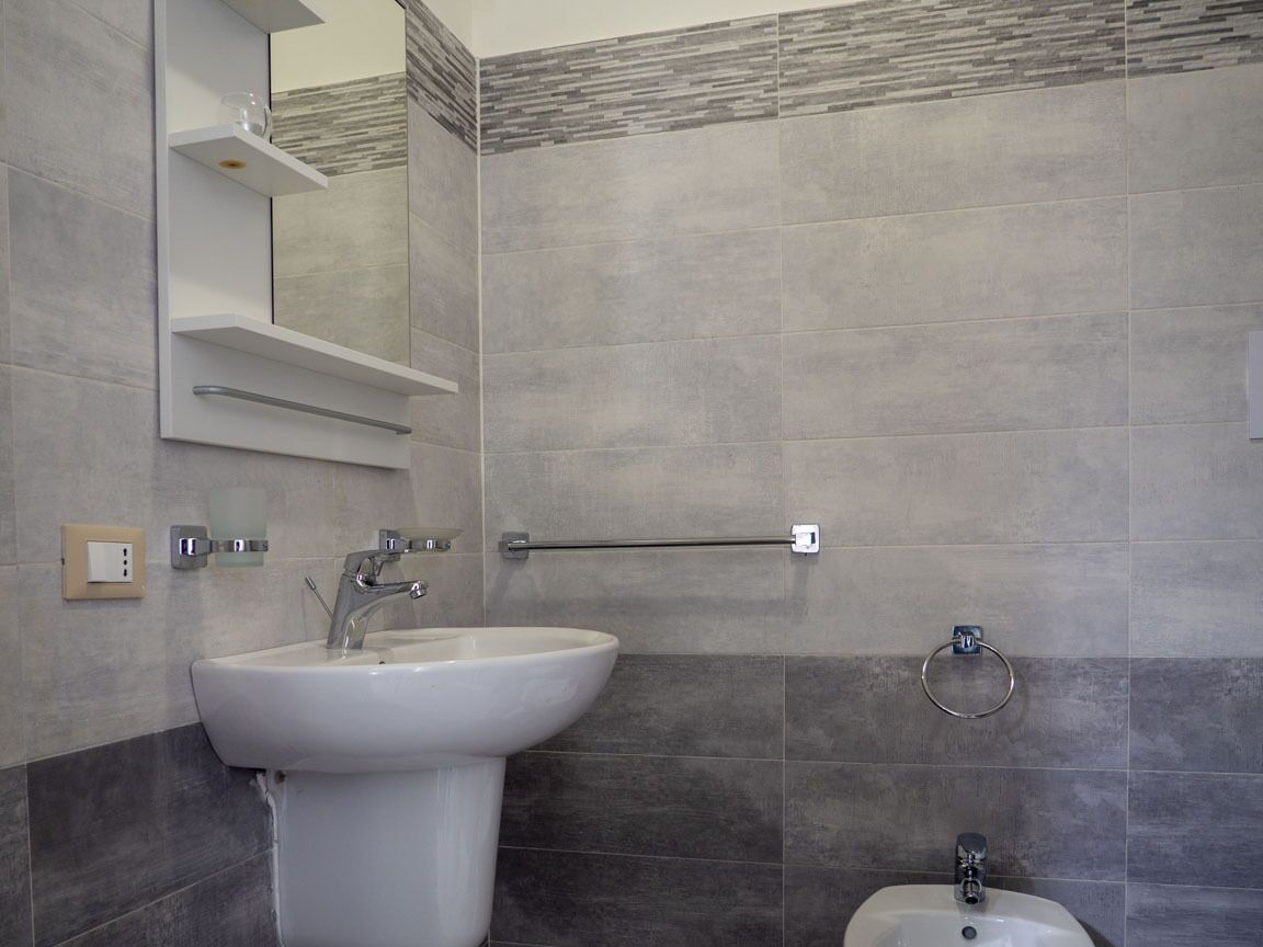 A bathroom with two sinks, a towel rack, and a mirror.