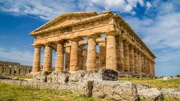 Un temple grec antique doté de nombreuses colonnes et présentant un style architectural classique.