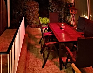 An outdoor patio with a wooden table and chairs, a small birdhouse, and a brick wall. - "Auberge-Jolie" - Central living with space and comfort. (Aachen)