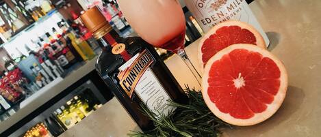 Eine Bar mit Flaschen und Gläsern, darunter eine Cointreau-Flasche und eine Flasche Original Gin.