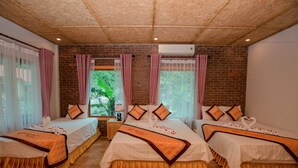 Une chambre d’hôtel avec deux lits, un mur en briques et une vue sur la verdure.