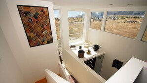 Una cocina moderna con ventanas amplias, un colcha en la pared y vistas a un paisaje rural.