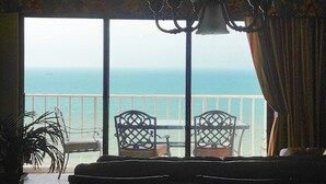 Un balcón con dos sillas y una mesa, con vistas al mar.