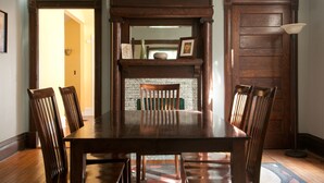 A dining room with a wooden table and chairs, a fireplace, and a door. - The Martin House - In the heart of historic downtown Lexington (Lexington)