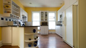 A kitchen with white cabinets, a central island with bowls, and a microwave. - The Martin House - In the heart of historic downtown Lexington (Lexington)
