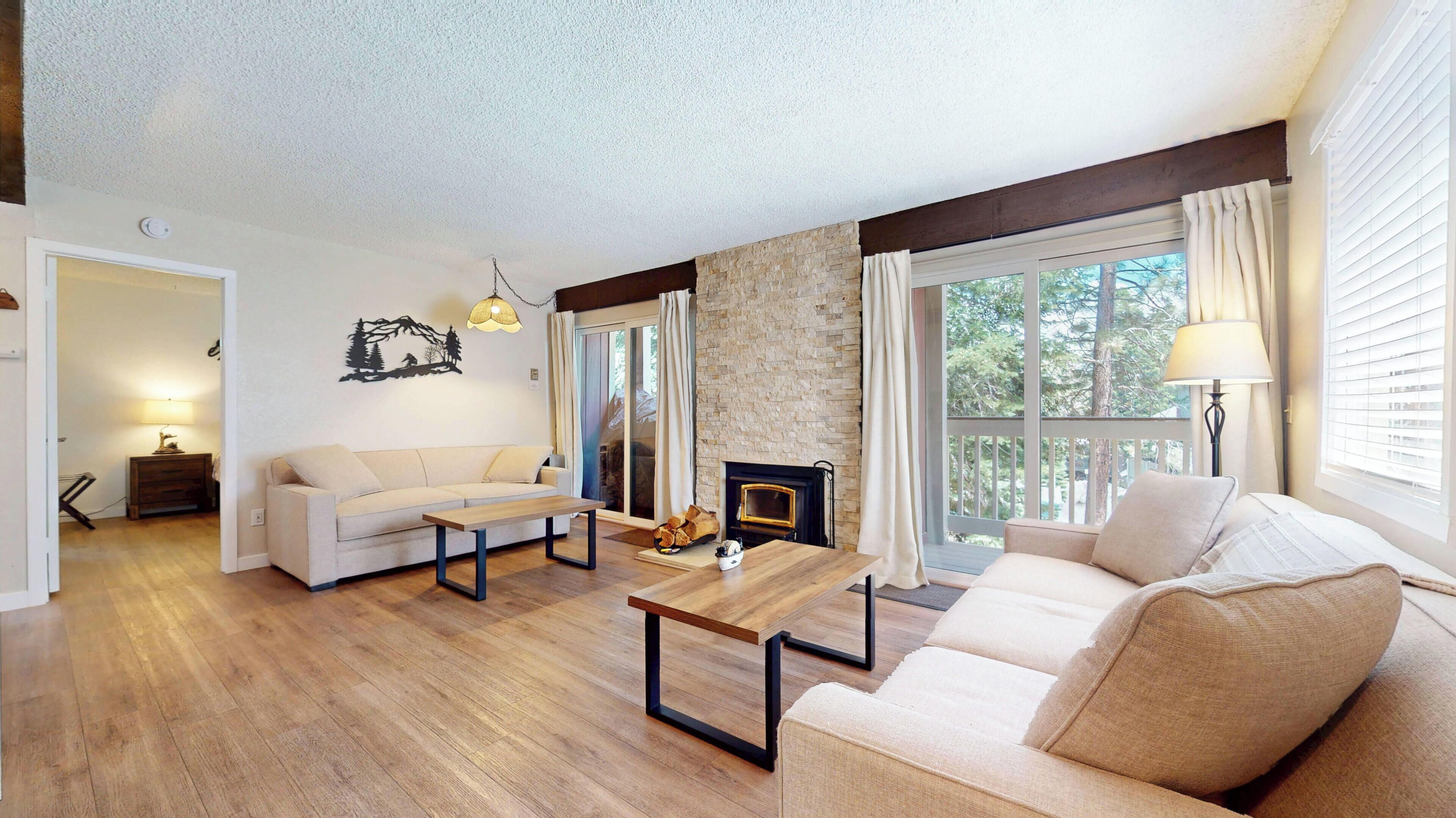A living room with a sofa, a coffee table, and a fireplace.