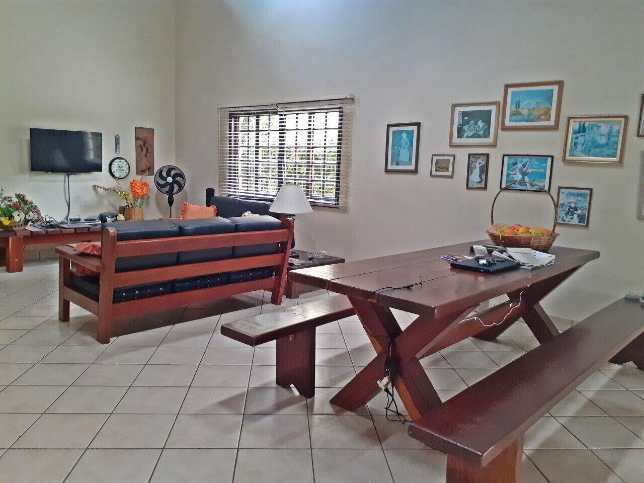 A living room with a wooden bench, a table, and a TV.