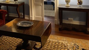 A room with a wooden dining table, two lamps, a chandelier, and framed pictures on the walls. - House of Saint Margaret (Ponta Delgada)