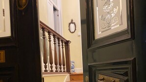 A wooden staircase with a black door on the right. - House of Saint Margaret (Ponta Delgada)