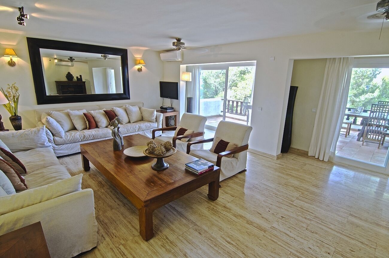 A spacious living room with a large sofa set, a wooden coffee table, and a television.