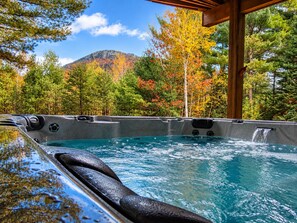 A hot tub with a waterfall feature, surrounded by autumn foliage and a mountain in the background. - Grand Ebs View Lodge, Luxury Log Home, Views, Hot Tub, Sauna, EV Charge, 3D Tour (Jay)