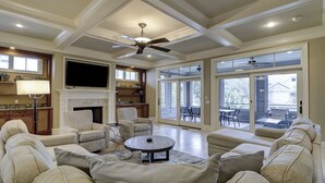 A spacious living room with a fireplace, comfortable seating, and large windows. - GORGEOUS 7 Bedroom 2nd Row Ocean Home with Private Pool & Game Room (Hilton Head Island)