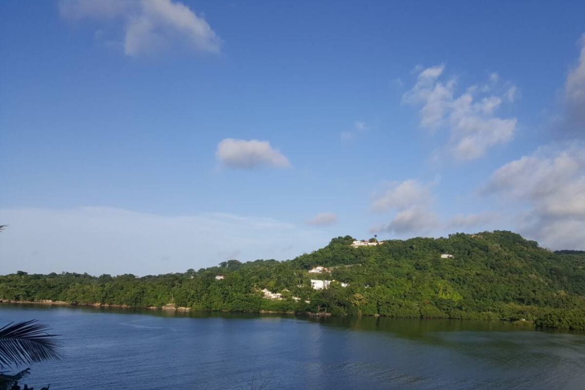A lake with a forested hill in the background.