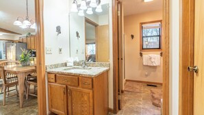 A bathroom with a wooden vanity, a large mirror, and a window. - BEAUTIFUL SMOKY MOUNTAINS
Peaceful and Secluded Peace of Heaven Cabin (Sevierville)