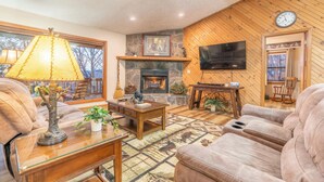 A cozy living room with a fireplace, comfortable seating, and a television mounted on the wall. - BEAUTIFUL SMOKY MOUNTAINS
Peaceful and Secluded Peace of Heaven Cabin (Sevierville)