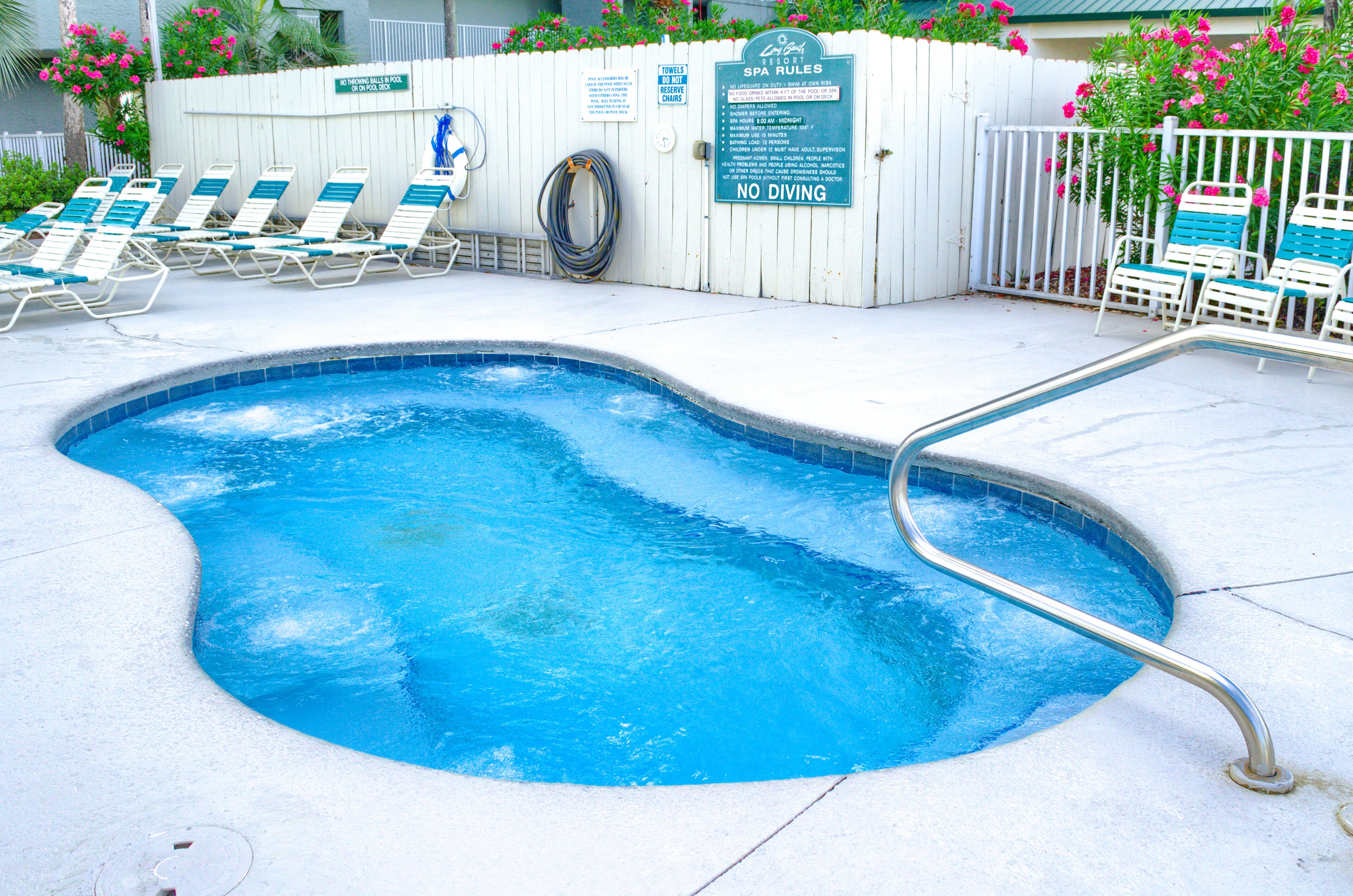 A swimming pool with lounge chairs and a no diving sign.