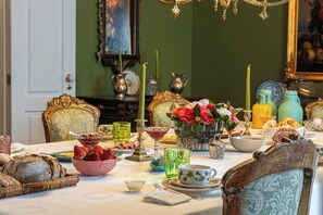 A dining table set with various dishes, a vase of flowers, and a chandelier. - Casa da Azenha (Lamego)