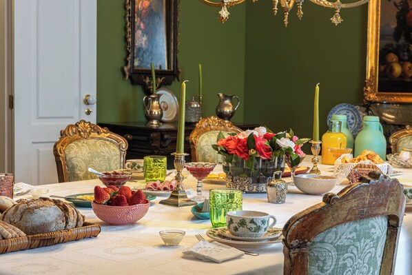 A dining table set with various dishes, a vase of flowers, and a chandelier.