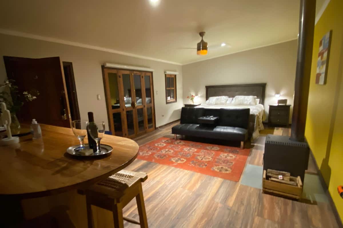 Una habitación con una mesa de comedor, un sofá, una cama y un ventilador de techo.