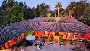 A traditional building with a tiled roof and multiple rooms. There is a courtyard with outdoor seating and a chessboard. - Casona Lo Aguirre Hotel y Convenciones (Talagante)